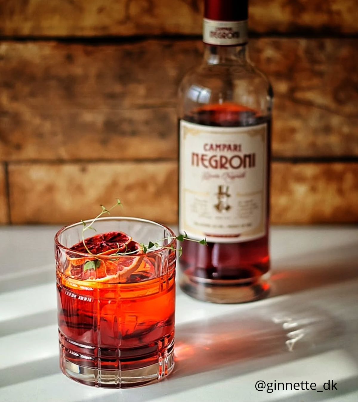 Any tumbler negroni next to campari flask